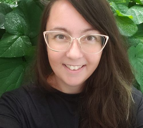 a photo of huntsville town council candidate kathleen may. she has brown hair and gold glasses. she looks into the camera and smiles